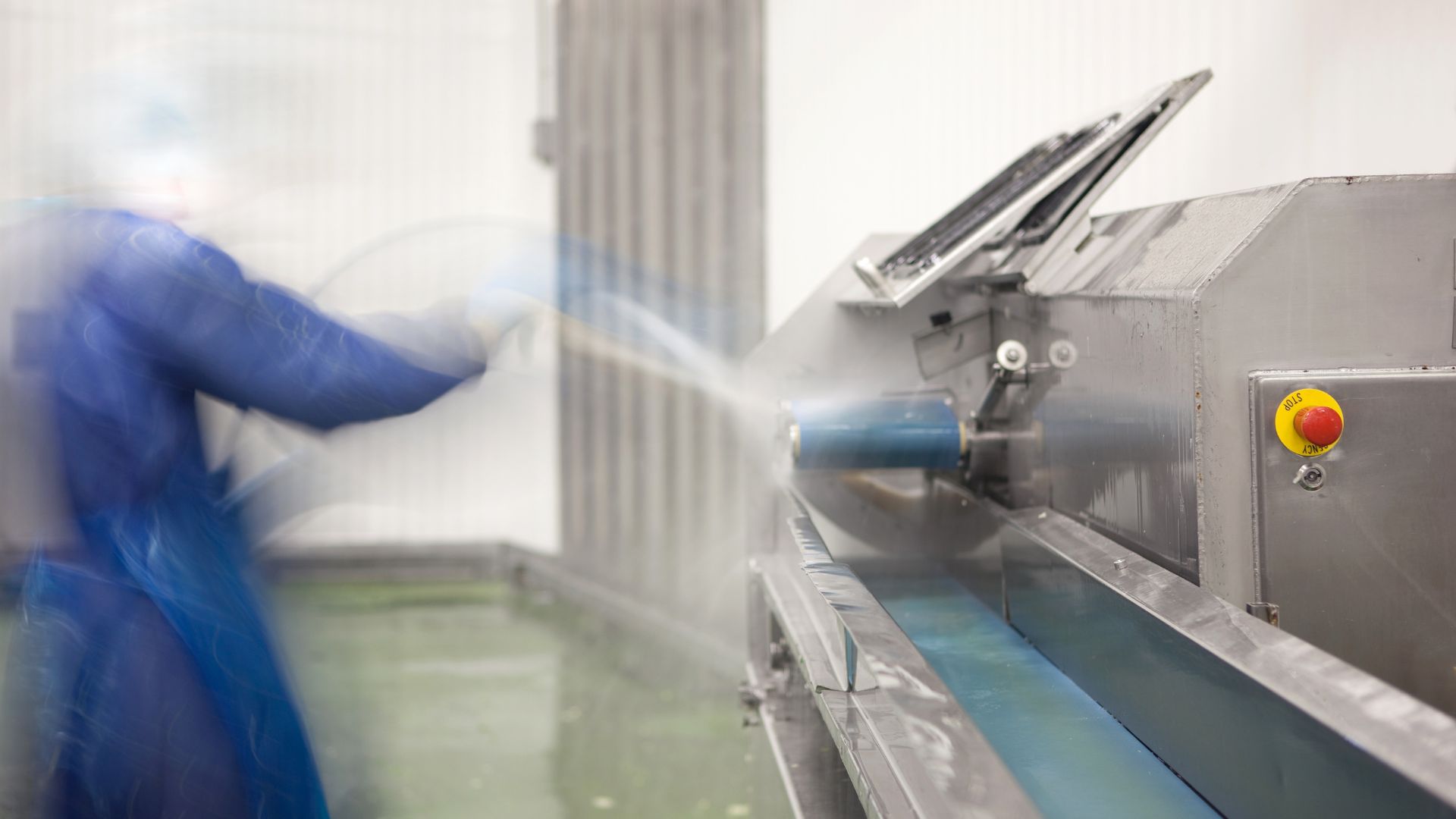 Medewerker gebruikt een reinigingsslang bij een procesinstallatie