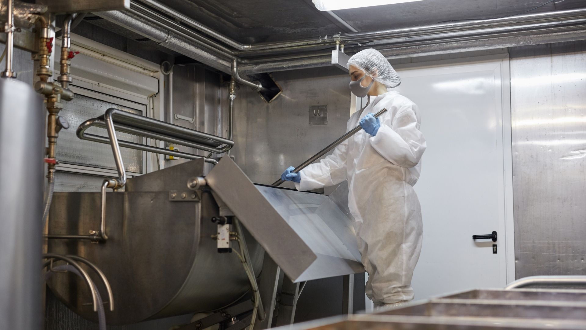 Vrouw maakt vaten schoon in een zuivelfabriek